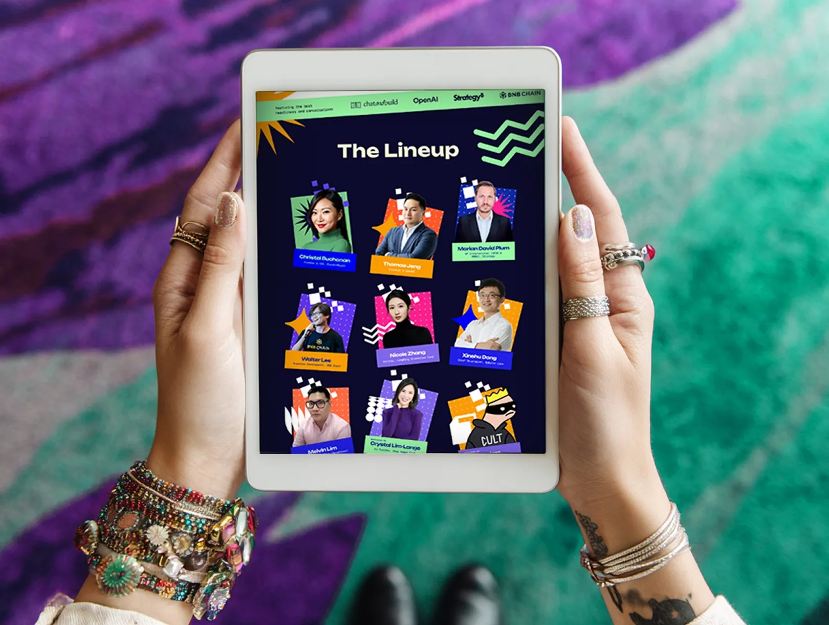 Hands holding a tablet that shows a conference line-up slide with speaker cards